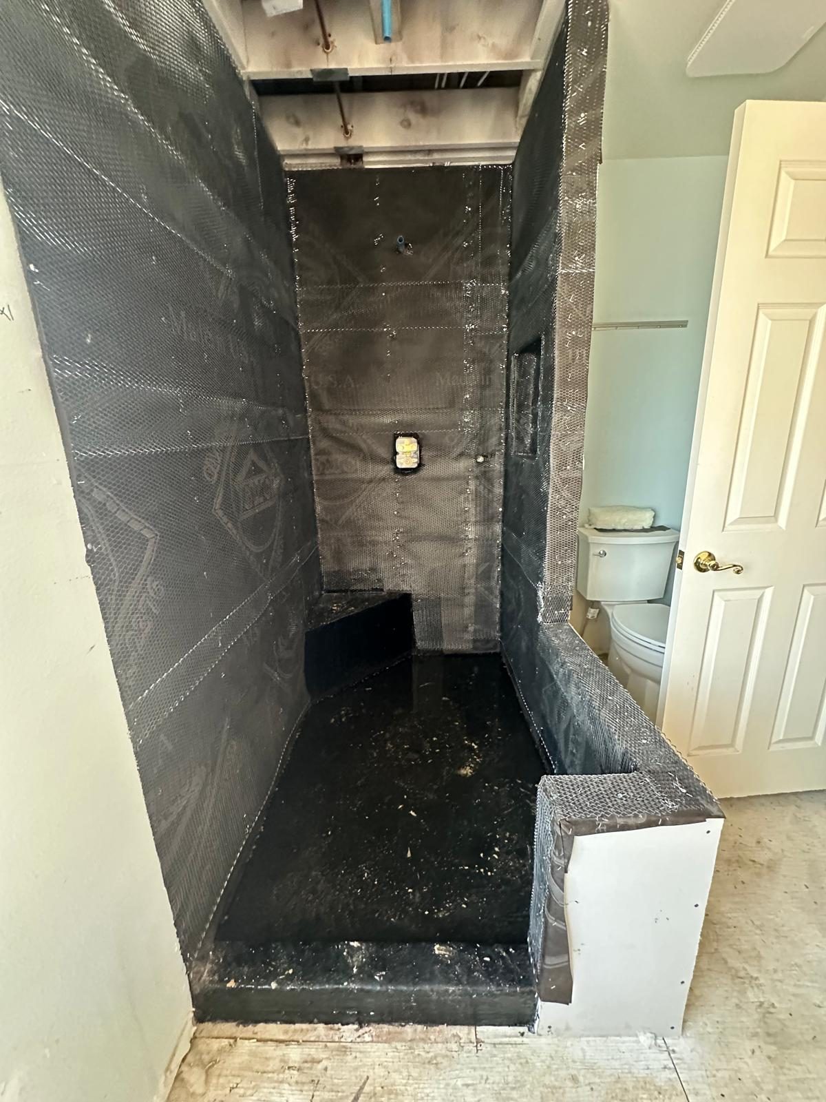 Shower walls wrapped in waterproofing membrane before tile