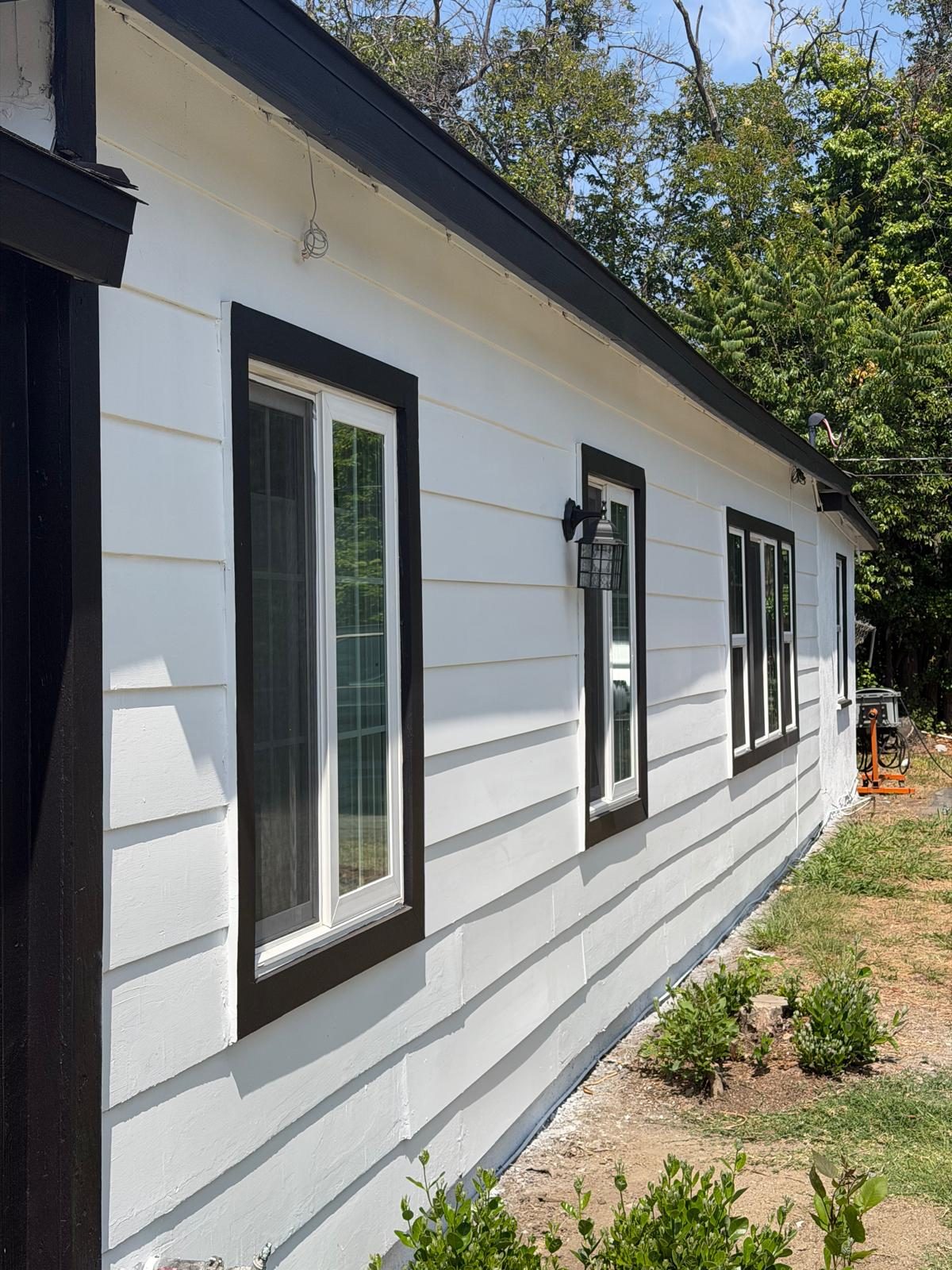 White horizontal siding with black window trim